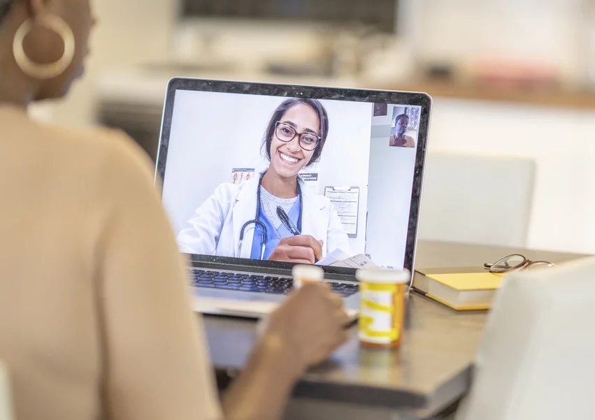 A patient has a telehealth visit with their doctor remotely in their home via video conferencing. The COVID-19 cause massive movement to telehealth since 2020.